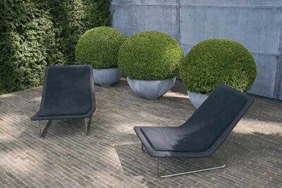 modern contemporary garden features with box balls and clay pavers with two chairs
