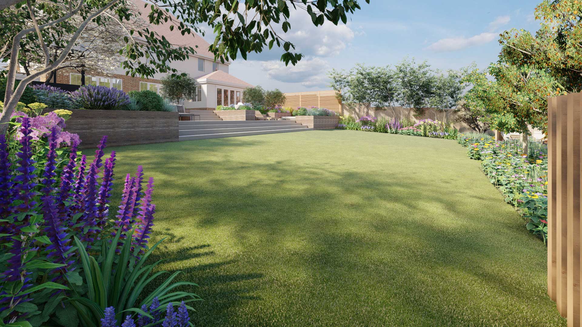 Large lawn space in a new garden with lots of flowers and large patio that has steps leading up to the house