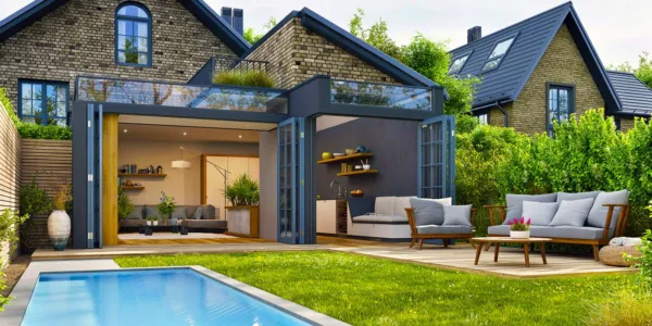 Modern house with patio area and solar panels and swimming pool with garden seating