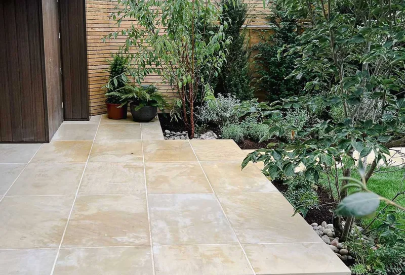 our portfolio medium sized Contemporary garden with rich green planting, mature trees and sawn sandstone paving next to an outside office